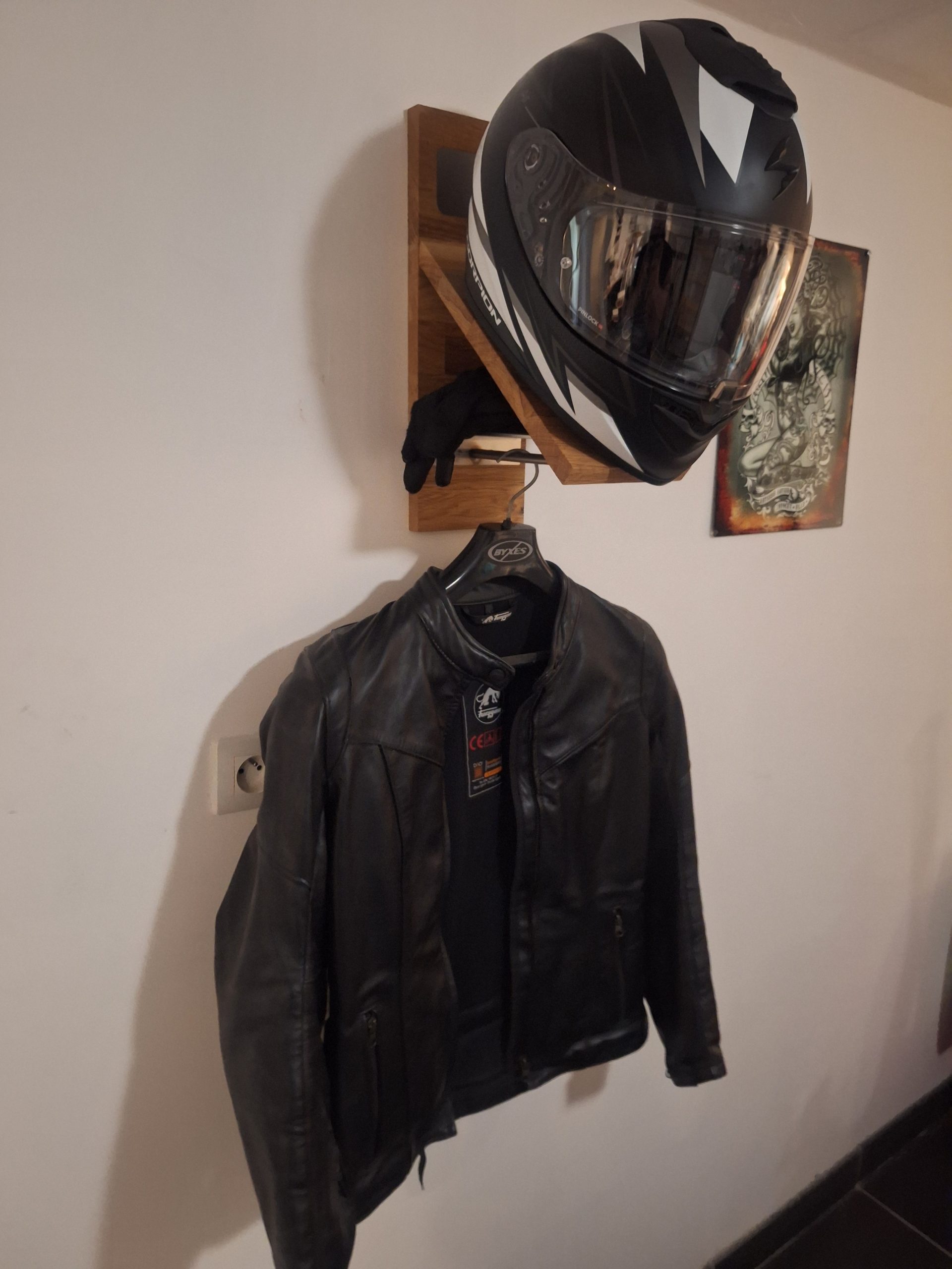 20250615_140154 Support mural pour casque moto – vue de gauche en situation, avec casque intégrale, gants et blouson en cuir suspendus.